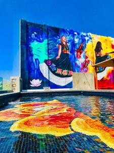 埃斯孔迪多港Cabane Container Boutique Hotel - ADULTS ONLY的一座游泳池,在建筑物的一侧画着画