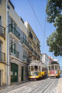 里斯本São Vicente 1797 Apartments的两辆无轨电车停在城市街道上