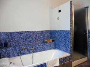 波焦阿卡伊阿诺Appartamento il Veggio的蓝色瓷砖浴室设有浴缸。