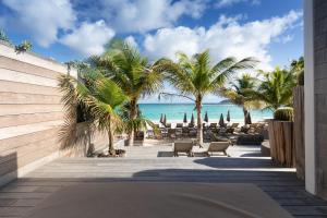 古斯塔维亚Pearl Beach Hotel的享有海滩和棕榈树景致的度假酒店