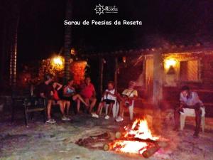 巴埃彭迪Fazenda da Roseta - Turismo Rural e Passeios a Cavalo -的一群人围坐在火炉旁