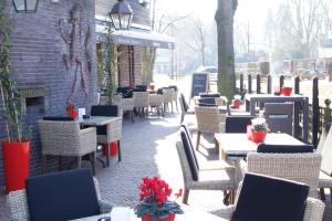 Terborg泰尔博赫德鲁德莱乌酒店的一座带桌椅的庭院和一座砖砌建筑