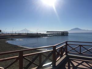 延基韦Hospedaje Lago Llanquihue的水面上的码头,太阳在后面