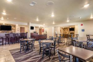 BridgeportCobblestone Inn & Suites - Bridgeport的一间带桌椅的餐厅和一间酒吧