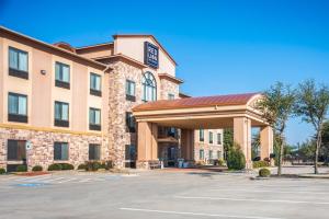 矿泉井城Red Lion Inn & Suites Mineral Wells的前面有一个停车位的酒店