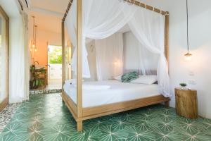 帕洛米诺Casa del Pavo Real Boutique Hostel的一间卧室设有一张绿地天蓬床。