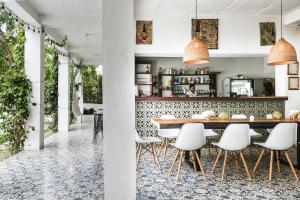 帕洛米诺Casa del Pavo Real Boutique Hostel的一间带桌子和白色椅子的用餐室