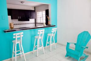 巴兰基亚QuillaHost Tropical Apartment的厨房配有蓝色的柜台和凳子