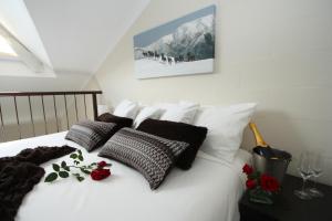 福尔斯克里克山岭顶峰山林小屋的一张带黑白枕头的床,床上有鲜花