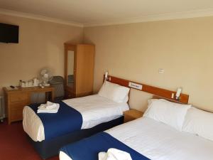 彼得伯勒Newark Hotel Peterborough的酒店客房设有两张床和电视。