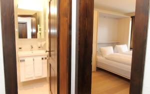 圣莫里茨Au Reduit 201的浴室设有床、水槽和镜子