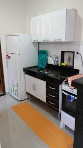 阿拉亚尔-杜卡布Casa em Arraial do Cabo的厨房配有白色橱柜和白色冰箱。