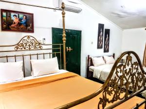 日惹达林加美兰酒店的一间卧室配有两张床和椅子