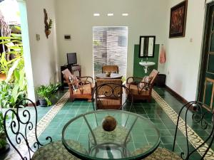 日惹达林加美兰酒店的客厅配有玻璃桌和椅子