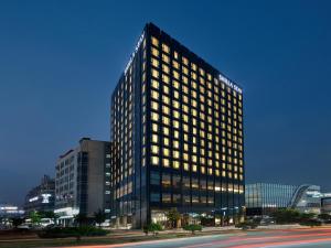 天安市Shilla Stay Cheonan - Samsung Display City的一座高大的建筑,城市里有很多窗户