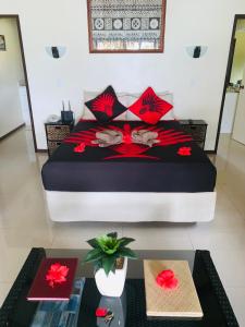 拉罗汤加穆里海岸酒店的一间卧室,床上有红色的鲜花