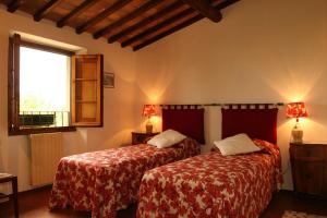 因普鲁内塔贝尔尼农庄度假屋的一间卧室设有两张床和窗户。