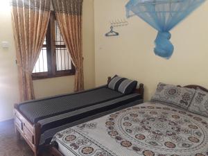 拜蒂克洛Naaval Beach Villa & Rooms的一间卧室设有一张床和一个窗口