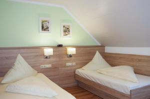 克伦巴赫狮子庭酒店的两张床位于带两盏挂在墙上的灯的房间