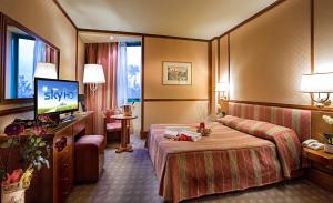 蒂沃利泰尔梅杜卡德斯特大酒店的配有一张床和一台平面电视的酒店客房