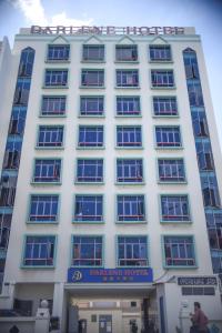 新加坡Darlene Hotel的白色的建筑,上面有标志