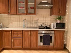 阿卢克斯内Apartamenti Bulvāris的厨房配有木制橱柜和炉灶烤箱。