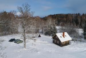 MālpilsJaunlidumnieki的雪中的小木屋,带车