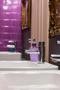 布达佩斯Baroque Hostel & Coworking的一间带两个盥洗盆和水龙头的浴室