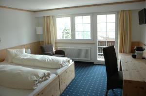 Bühler兰格福斯恩酒店的酒店客房配有两张床和一张书桌