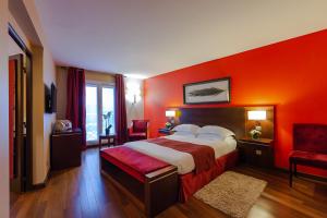 安东尼德贝尔尼酒店的酒店客房,设有床铺和红色的墙壁
