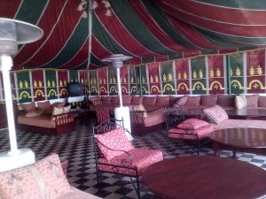Aït el Rhazi里亚德阿格尼尔多尔酒店的一间带桌椅的房间和一个帐篷