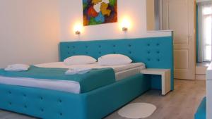 旧瓦马Casa OK by OVO的一张带蓝色床头板的睡床