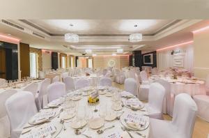阿尔么丽亚托雷鲁兹中心酒店的宴会厅配有白色的桌子和白色的椅子