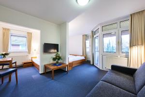 瓦尔斯罗德Krelinger Freizeit- und Tagungszentrum的酒店客房设有沙发、床和窗户。