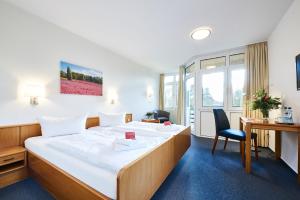 瓦尔斯罗德Krelinger Freizeit- und Tagungszentrum的配有一张床和一张书桌的酒店客房