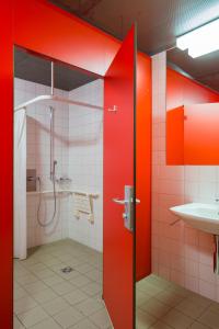 蓬特雷西纳蓬特雷西纳青年旅舍的浴室设有红色的墙壁、淋浴和水槽