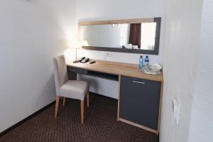 伊热夫斯克依兹酒店的客房设有带镜子和椅子的书桌