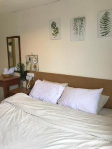 邦咯coralbay apartment pangkor island的卧室内的一张带白色床单和枕头的床