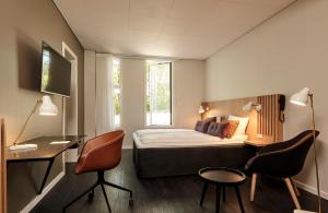 霍尔特克伦威尔酒店的卧室配有一张床、一张桌子和椅子