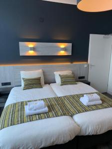 萨斯范亨特Hotel & Appartementen Royal的一间卧室配有两张带毛巾的床