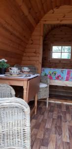 基尔肯尼Glamping at Treegrove的小屋内带桌子和藤椅的用餐室