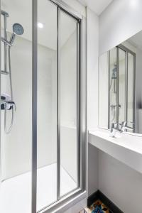 Viry格尼沃萨特朱丽恩格沃斯酒店的带淋浴、盥洗盆和镜子的浴室