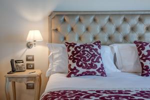 乔治堡Borgo La Chiaracia Resort & SPA的一间卧室配有一张带紫色和白色枕头的床