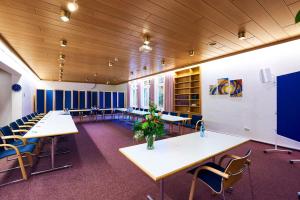 瓦尔斯罗德Krelinger Freizeit- und Tagungszentrum的教室里配有桌椅