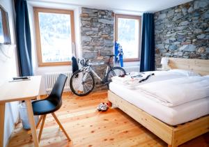 艾罗洛Bed&Bike Tremola San Gottardo的一间卧室配有一张床、一张桌子和一辆自行车