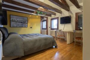 威尼斯威尼斯玛格丽特楼酒店的一间卧室配有一张床、一张书桌和一台电视