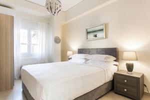雅典Athens Homes的白色的卧室设有一张大床和一个窗户