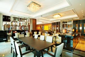 芭堤雅市中心Intimate Hotel Pattaya - SHA Extra Plus的一间带木桌和椅子的用餐室