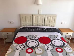 拉斯内格拉斯EL DUENDE的一间卧室配有一张带红白毯子的床