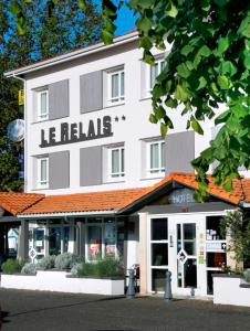比斯卡罗斯Logis Hôtel Le Relais的一座大型的白色建筑,与酒店同在
